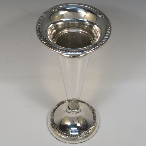 A very handsome Antique Edwardian Sterling Silver large table flower vase, having a plain tapering round body, with applied gadroon and shell borders, and sitting on a round pedestal foot. This elegant antique silver flower vase was made by A. and J. Zimmerman of Birmingham in 1909. The dimensions of this fine hand-made antique silver vase are height 25.5 cms (10 inches), diameter at top 11 cms (4.3 inches).   