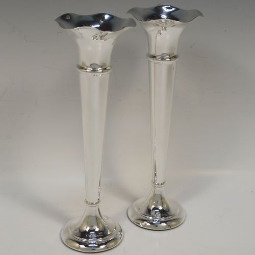 A handsome Antique Sterling Silver pair of table flower vases, having very plain round tapering bodies, with petal-shaped mouths, and sitting on round pedestal feet. These elegant silver vases were made by Henry Miller of Birmingham in 1912. The dimensions of these fine hand-made pair of antique silver vases are height 23 cms (9 inches), and diameter at top 7 cms (2.75 inches).  