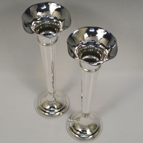 A handsome Antique Sterling Silver pair of table flower vases, having very plain round tapering bodies, with petal-shaped mouths, and sitting on round pedestal feet. These elegant silver vases were made by Henry Miller of Birmingham in 1912. The dimensions of these fine hand-made pair of antique silver vases are height 23 cms (9 inches), and diameter at top 7 cms (2.75 inches).  