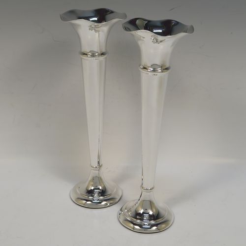 A handsome Antique Sterling Silver pair of table flower vases, having very plain round tapering bodies, with petal-shaped mouths, and sitting on round pedestal feet. These elegant silver vases were made by Henry Miller of Birmingham in 1912. The dimensions of these fine hand-made pair of antique silver vases are height 23 cms (9 inches), and diameter at top 7 cms (2.75 inches).  