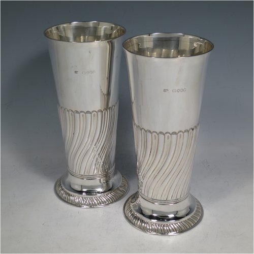 An Antique Victorian Sterling silver pair of table flower vases, having round bodies with tapering sides, hand-chased half-fluted decoration, and sitting on pedestal feet. Made by Henry Stratford of London in 1889. The dimensions of these fine hand-made antique silver pair of vases are height 19 cms (7.5 inches), diameter at top 8.5 cms (3.3 inches), and they weigh a total of approx. 487g (15.7 troy ounces). Please note that these vases are not loaded.   