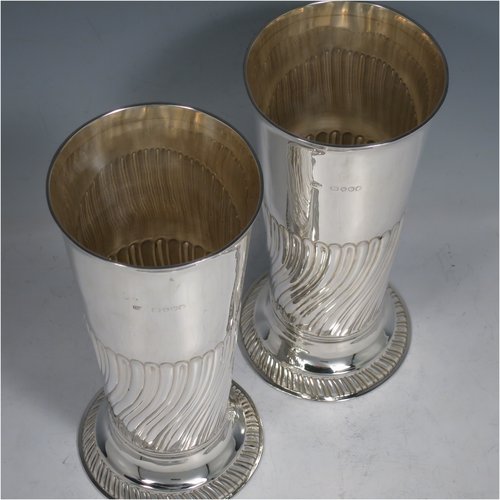 An Antique Victorian Sterling silver pair of table flower vases, having round bodies with tapering sides, hand-chased half-fluted decoration, and sitting on pedestal feet. Made by Henry Stratford of London in 1889. The dimensions of these fine hand-made antique silver pair of vases are height 19 cms (7.5 inches), diameter at top 8.5 cms (3.3 inches), and they weigh a total of approx. 487g (15.7 troy ounces). Please note that these vases are not loaded.   