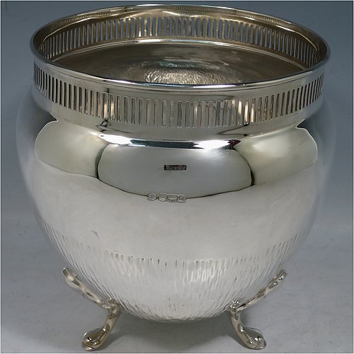 Antique Sterling Silver pair of table Arts & Crafts Wine Coolers or planters, having round bellied body with tapering sides, with hand-hammered tree bark-like decoration extending half-way up their bodies, a hand-pierced geometrical gallery top border, and sitting on four cast foliate feet. Made by William Hutton of Sheffield in 1921. The dimensions of this fine hand-made silver pair of planters or vases are height 18.5 cms (7.25 inches), diameter at top 16 cms (6.3 inches), and they weigh a total of approx. 1,635g (52.7 troy ounces). Please note that these vases are not loaded.    