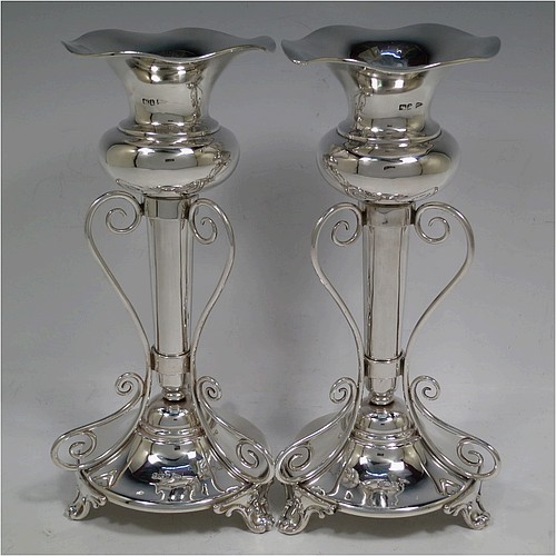 A very pretty and unusual pair of Antique Edwardian Sterling Silver Art Nouveau style vases, having removable central bodies, sitting in a frame with wire-work scrolls, attached to round bases with three scroll feet. Made by Walker and Hall of Sheffield in 1907. The dimensions of this fine pair of hand-made antique silver Art Nouveau vases are height 24 cms (9.5 inches), and diameter at bases 11 cms (4.3 inches). Please note that these vases are not loaded, and the total weight of silver is 640g (20.6 troy ounces)..    