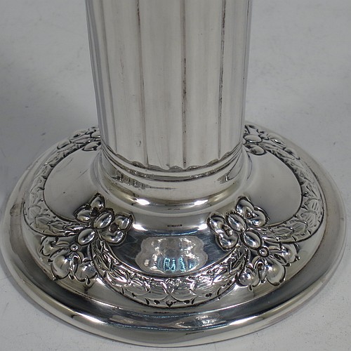 A very pretty Antique Victorian Sterling Silver pair of table flower vases, having round bodies with tapering sides and hand-chased neoclassical style decoration with half-fluting, ribbon bows, and swags, and sitting on pedestal feet. Made by Henry Atkins of Sheffield in 1892. The dimensions of these fine hand-made antique silver pair of vases are height 15 cms (6 inches), diameter at top 6.5 cms (2.5 inches), and they weigh at total of approx. 200g (6.5 troy ounces). Please note that these vases are not loaded.    