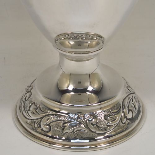 A pretty Scottish Sterling Silver large table flower vase, having a round bellied body, with hand-chased floral decoration, and sitting on a pedestal foot. This beautiful sterling silver single vase was made by the Cooper Brothers of Edinburgh in 2004. The dimensions of this fine hand-made silver vase are height 29 cms (11.5 inches), diameter of main body 12 cms (4.75 inches), and it weighs approx. 498g (16 troy ounces). Please note that this vase is not loaded.   