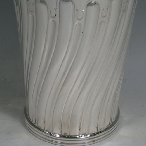 Antique Victorian sterling silver large table flower vase, having a tapering round body, with hand-chased swirl half-fluted decoration, an applied reeded band at the base, and a gold-gilt interior. Made by Susanah Brasted of London in 1889. The dimensions of this sterling silver vase are height 24 cms (9.5 inches), diameter at top 15 cms (6 inches). Weight approx. 612g (19.7 troy ounces).