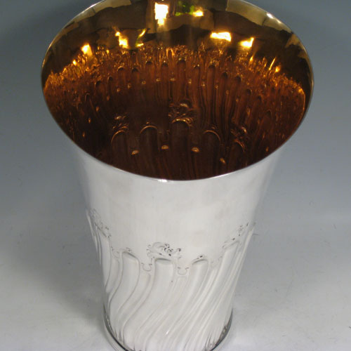 Antique Victorian sterling silver large table flower vase, having a tapering round body, with hand-chased swirl half-fluted decoration, an applied reeded band at the base, and a gold-gilt interior. Made by Susanah Brasted of London in 1889. The dimensions of this sterling silver vase are height 24 cms (9.5 inches), diameter at top 15 cms (6 inches). Weight approx. 612g (19.7 troy ounces).