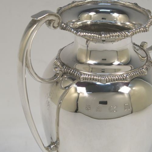 A heavy and very handsome Antique Sterling Silver single vase, having a plain round body with tapering sides, with two flying scroll side handles, with applied shaped gadroon top borders, and all sitting on a pedestal foot with a square base. Made by Stewart Dawson and Co., of Birmingham in 1912. The dimensions of this fine hand-made antique silver vase are height 17 cms (6.5 inches), spread across arms 12 cms (4.75 inches), diameter of body at widest point 8 cms (3 inches), and it weighs approx. 311g (10 troy ounces). Please note that this vase is not loaded.   