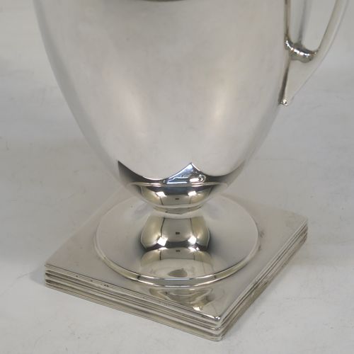 A heavy and very handsome Antique Sterling Silver single vase, having a plain round body with tapering sides, with two flying scroll side handles, with applied shaped gadroon top borders, and all sitting on a pedestal foot with a square base. Made by Stewart Dawson and Co., of Birmingham in 1912. The dimensions of this fine hand-made antique silver vase are height 17 cms (6.5 inches), spread across arms 12 cms (4.75 inches), diameter of body at widest point 8 cms (3 inches), and it weighs approx. 311g (10 troy ounces). Please note that this vase is not loaded.   