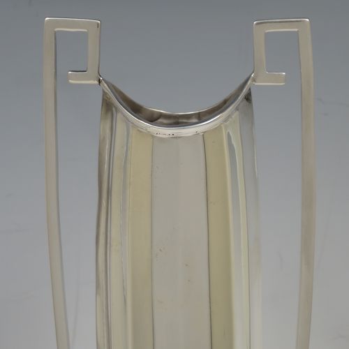 A very unusual and pretty pair of Art Deco Sterling Silver table flower vases, having tall panelled bodies with square cross-section side handles, and sitting on pedestal feet. Made by William Henry Sparrow of Birmingham in 1938. The dimensions of these fine hand-made pair of Art Deco silver vases are height 30 cms (11.75 inches), and diameter at base 8 cms (3.25 inches).   