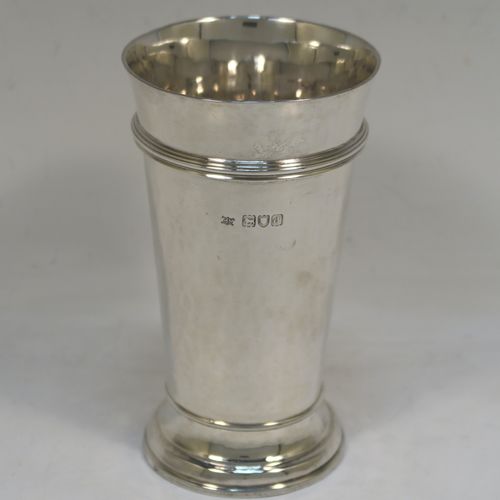 A very elegant Antique Victorian Sterling Silver table flower vase, having a round body with tapering sides, having hand-hammered decoration and an applied reeded upper band, with a vacant cartouche on one side, and all sitting on a pedestal foot. This handsome antique silver vase was made by Moss Morris of London in 1899. The dimensions of this fine hand-made antique silver vase are height 14 cms (5.5 inches), diameter at top 8 cms (3 inches), and it weighs approx. 226g (7.3 troy ounces).  