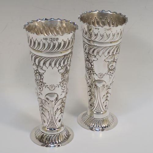 A very pretty Antique Victorian Sterling Silver pair of table flower vases, having round hand-chased bodies with tapering sides, with floral and fluted decoration, and all sitting on pedestal feet. These beautiful antique silver vases were made by Mappin and Webb of London in 1896. The dimensions of these fine hand-made antique silver pair of vases are height 16 cms (6.25 inches), diameter at top 6.5 cms (2.5 inches), and they weigh at total of approx. 200g (6.5 troy ounces). Please note that these vases are not loaded, so the whole weight is silver.   