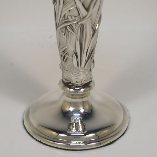 A very pretty Antique Edwardian Sterling Silver pair of table flower vases, having round hand-chased bodies with tapering sides and floral decoration, and all sitting on pedestal feet. These beautiful antique silver vases were made by William Comyns of London in 1903. The dimensions of these fine hand-made antique silver pair of vases are height 16.5 cms (6.5 inches), and diameter at top 7 cms (2.75 inches).   