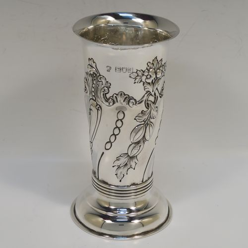 A very pretty Antique Victorian Sterling Silver table flower vase, having a round body with tapering sides and hand-chased floral and swirl-fluted decoration, and all sitting on pedestal feet. This beautiful antique silver vase was made by Charles Stuart Harris of London in 1899. The dimensions of these fine hand-made antique silver vase are height 15 cms (6 inches), diameter at top 7.5 cms (3 inches), and it weighs approx. 172g (5.5 troy ounces). Please note that this vase is not loaded, so the whole weight is silver.   