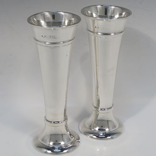 A very handsome pair of Antique Sterling Silver table flower vases, having very plain round tapering bodies, with upper and lower applied bands , and sitting on round pedestal feet. These elegant silver vases were made by Goldsmiths and Silversmiths of London in 1912. The dimensions of these fine hand-made pair of antique silver vases are height 18 cms (7 inches), diameter at top 6.5 cms (2.5 inches), and they weigh a total of 311g (10 troy ounces). Please note that these vases are not filled, so the whole weight is silver.   