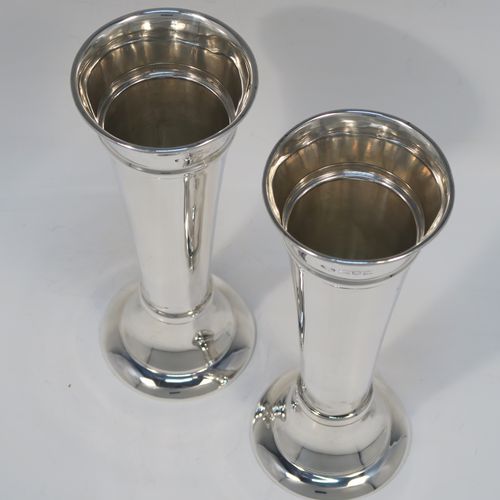 A very handsome pair of Antique Sterling Silver table flower vases, having very plain round tapering bodies, with upper and lower applied bands , and sitting on round pedestal feet. These elegant silver vases were made by Goldsmiths and Silversmiths of London in 1912. The dimensions of these fine hand-made pair of antique silver vases are height 18 cms (7 inches), diameter at top 6.5 cms (2.5 inches), and they weigh a total of 311g (10 troy ounces). Please note that these vases are not filled, so the whole weight is silver.   