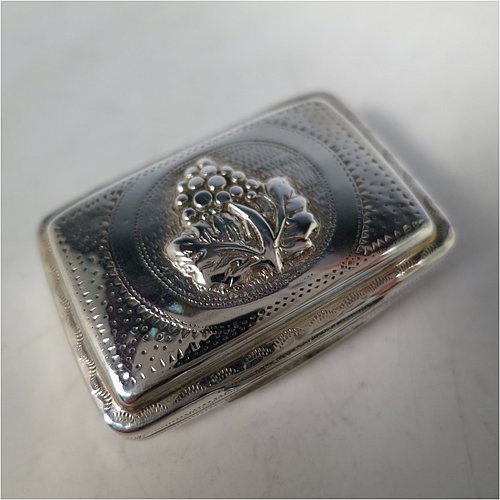 An Antique Georgian Sterling Silver vinaigrette, having a rectangular body with an applied raspberry and leaf motif surrounded by hand-engraved stipple-work on top and hand-engraved floral work on the base, a gold-gilt interior, and a hand-pierced floral grill. Made by John Bettridge of Birmingham in ca. 1820. The dimensions of this fine hand-made antique silver vinaigrette are length 3.5 cms (1.4 inches), width 2.5 cms (1 inch), and depth 1.2 cms (0.5 inch).    