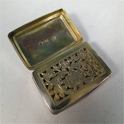 An Antique Georgian Sterling Silver vinaigrette, having a rectangular body with an applied raspberry and leaf motif surrounded by hand-engraved stipple-work on top and hand-engraved floral work on the base, a gold-gilt interior, and a hand-pierced floral grill. Made by John Bettridge of Birmingham in ca. 1820. The dimensions of this fine hand-made antique silver vinaigrette are length 3.5 cms (1.4 inches), width 2.5 cms (1 inch), and depth 1.2 cms (0.5 inch).    