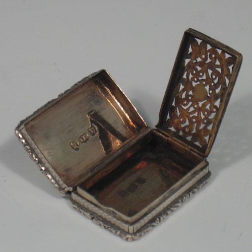 An Antique Georgian Sterling Silver & gold-gilt vinaigrette, having a rectangular body with double cast floral borders top & bottom, with engine-turned decoration, a gold-gilt interior, and a hand-pierced floral grill. Made in Birmingham in 1831. The dimensions of this fine hand-made antique silver vinaigrette are length 3.5 cms (1.3 inches).