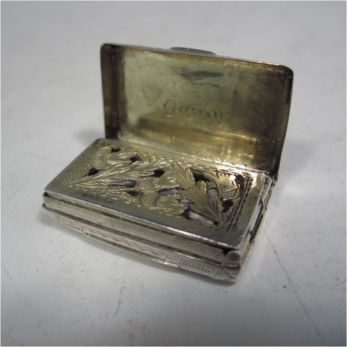 An Antique Georgian Sterling silver vinaigrette, in a Purse or Satchel form, having hand-engraved decoration, a gold-gilt interior, and a hand-pierced grill with thistle work. Made by Simpson & Son of Birmingham in 1816. The dimensions of this fine hand-made silver vinaigrette are length 2.8 cms (1.1 inches), width 1.7 cms (0.7 inches), and depth 0.8 cms (0.3 inches).