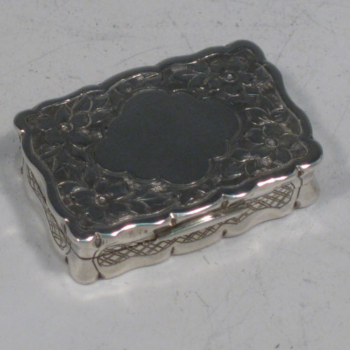 Antique Victorian sterling silver vinaigrette, having a rectangular shaped body with hand-engraved floral decoration (with roses and ferns), a hinged lid with vacant cartouche, and a gold-gilt interior with hinged hand-pierced and chased grill. Made by George Unite of Birmingham in 1838. The dimensions of this fine hand-made silver vinaigrette are length 3.5 cms (1.3 inches), and width 2.5 cms (1 inch).    