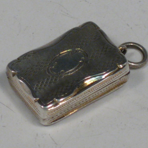 Antique Victorian sterling silver vinaigrette, having a rectangular body with with engine-engraved decoration and a vacant cartouche, a hinged lid, a gold-gilt interior with hinged hand-pierced and chased grill, and a side ring. Made by Aston & Son, of Birmingham in 1858. The dimensions of this fine hand-made silver vinaigrette are length 2 cms (0.75 inches), and width 1.5 cms (0.5 inches).