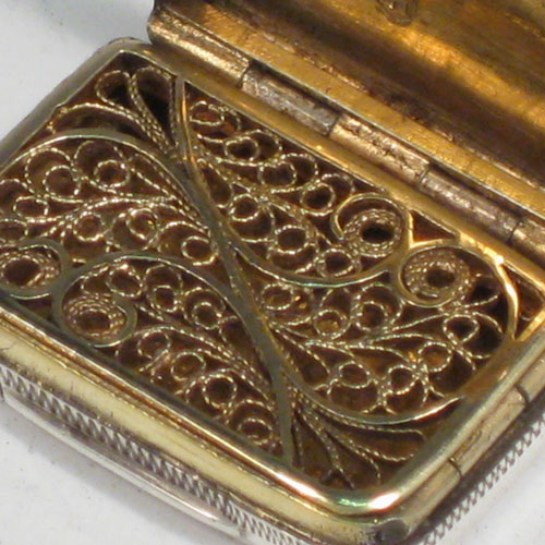 Antique Georgian sterling silver vinaigrette, having a rectangular body with hand-engraved Greek-Key decoration, a hinged lid, and a gold-gilt interior with hinged fillagree grill. Made by Samuel Pemberton of Birmingham in 1805. The dimensions of this fine hand-made silver vinaigrette are length 2.5 cms (1 inches), and width 2 cms (0.75 inches).   