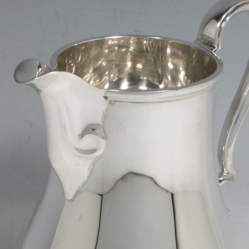 Sterling silver water jug, in a George I beer jug style, having a plain round bellied body, sparrow-beak spout, scroll handle, and sitting on a pedestal foot. Made by Henry Atkins of Sheffield in 1936. The dimensions of this fine hand-made silver water jug are height 21 cms (8.25 inches), length 16.5 cms (6.5 inches), length 14 cms (5.5 inches), and it weighs approx. 449g (14.5 troy ounces). Please note that this silver water jugs size would be perfect for serving two people.