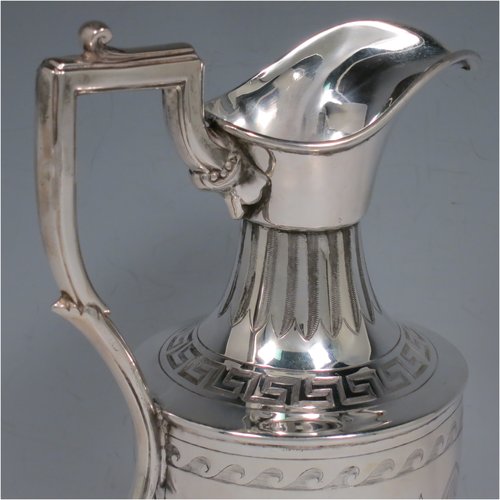 An Antique Victorian Sterling Silver water jug, in a Neoclassical Georgian style, having a hand-engraved body with Greek-Key and floral decoration, a plain spout and a scroll handle with thumb-piece, all sitting on a pedestal foot. Made by James Dixon & Sons of Sheffield in 1871. The dimensions of this fine hand-made antique silver water jug are height 20 cms (8 inches), length 12 cms (4.75 inches), and it weighs approx. 280g (9 troy ounces). Please note that this silver water jugs size would be perfect for serving two people.   