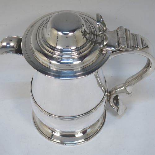 A very handsome Antique Georgian Sterling Silver water or beer jug, having a plain round bellied body with an applied central reeded girdle, a plain pouring spout, a scroll handle with heart-shaped terminal, a hinged domed lid with pierced thumb-piece, and sitting on a plain round stepped pedestal foot. Made by John Payne of London in 1754. The dimensions of this fine hand-made antique silver beer or water jug are height 21 cms (8.5 inches), length 21 cms (8.5 inches), and it weighs approx. 870g (28 troy ounces).  