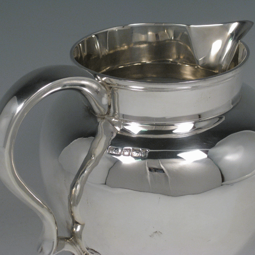    Antique Edwardian sterling silver water jug with scoll handle, baluster body, sparrow-beak, and pedestal foot. Made by Henry Atkins of Sheffield in 1902. Height 16.5 cms (6.5 inches), length 20 cms (8 inches). Weight approx. 17.5 troy ounces (543g).