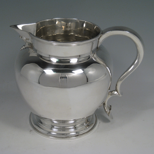    Antique Edwardian sterling silver water jug with scoll handle, baluster body, sparrow-beak, and pedestal foot. Made by Henry Atkins of Sheffield in 1902. Height 16.5 cms (6.5 inches), length 20 cms (8 inches). Weight approx. 17.5 troy ounces (543g).