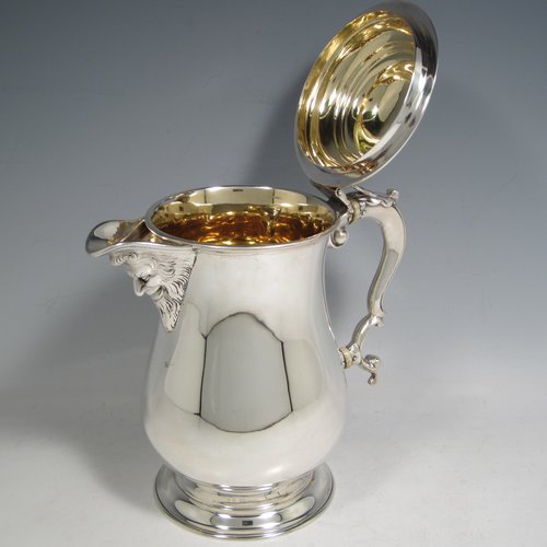 Antique Victorian sterling silver water or beer jug, having a plain round baluster body, with insulated scroll handle, a hinged domed lid with hand-pierced thumb-piece, a spout with hand-chased Bacchus face, a gold-gilt interior, and all sitting on a collet foot. Made by Robert Hennell of London in 1871. The dimensions of this fine hand-made silver beer or water jug are height 21 cms (8.25 inches), length 20 cms (8 inches), and it weighs approx. 777g (25 troy ounces).