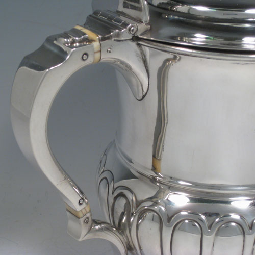 A large and very handsome Antique Georgian Sterling Silver water or beer jug, having a round body with hand-chased half-fluted decoration, plain pouring spout, an insulated scroll handle, a hinged domed lid with cast acanthus leaf thumb-piece, and sitting on a plain round pedestal foot. Made by J. McKay of Edinburgh in 1811. The dimensions of this fine hand-made antique silver beer or water jug are height 23 cms (9 inches), length 26 cms (10.25 inches), and it weighs approx. 991g (32 troy ounces)