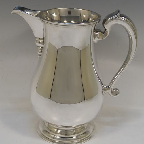 A very handsome and large Silver Plated water jug, in a George I beer jug style, having a plain round bellied body, a sparrow-beak spout, a scroll handle, and sitting on a pedestal foot. This elegant silver-plated water or beer jug was made in ca. 1930. The dimensions of this fine hand-made silver plated  water jug are height 24 cms (9.5 inches), and length 22 cms (8.5 inches).   