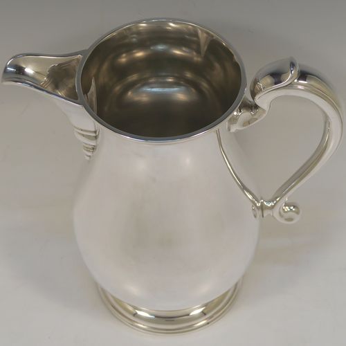 A very handsome and large Silver Plated water jug, in a George I beer jug style, having a plain round bellied body, a sparrow-beak spout, a scroll handle, and sitting on a pedestal foot. This elegant silver-plated water or beer jug was made in ca. 1930. The dimensions of this fine hand-made silver plated  water jug are height 24 cms (9.5 inches), and length 22 cms (8.5 inches).   