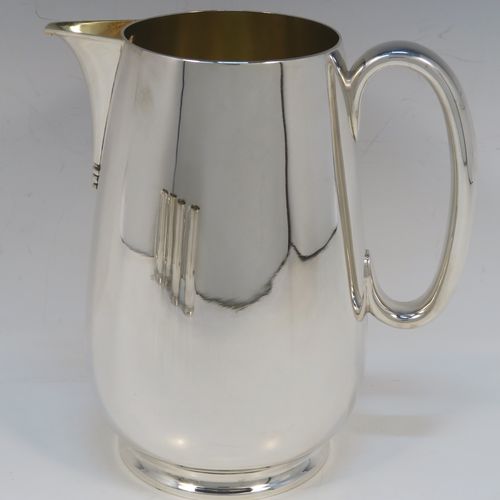 A very handsome Antique Edwardian Silver-Plated  water jug with four mugs, in a very plain style, having round bellied bodies with tapering sides, a sparrow-beak spout, scroll side-handles, gold-gilt interiors, and all sitting on collet feet. This antique silver-plated water jug serving set was made in ca. 1900 by Martin Hall and Co., of Sheffield. The dimensions of this fine hand-made silver-plated water jug are height 20 cms (8 inches), and height of mugs are 10 cms (4 inches).   