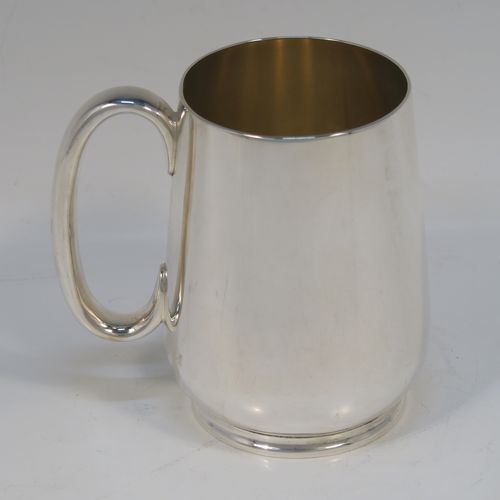 A very handsome Antique Edwardian Silver-Plated  water jug with four mugs, in a very plain style, having round bellied bodies with tapering sides, a sparrow-beak spout, scroll side-handles, gold-gilt interiors, and all sitting on collet feet. This antique silver-plated water jug serving set was made in ca. 1900 by Martin Hall and Co., of Sheffield. The dimensions of this fine hand-made silver-plated water jug are height 20 cms (8 inches), and height of mugs are 10 cms (4 inches).   