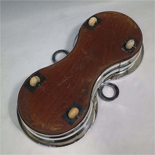 A rare Antique Georgian Old Sheffield plated wine bottle coaster trolley, in a Regency style, having round bellied bodies, with applied gadroon borders, with two stopper side-holders, and with wood-turned bases with silver buttons, all sitting on an oak frame with bone wheels. Made in ca. 1815. The dimensions of this fine hand-made antique wine coaster bottle trolley are diameter of coasters 15 cms (6 inches), and total length 32cms (12.5 inches). Please note that the buttons are crested.   