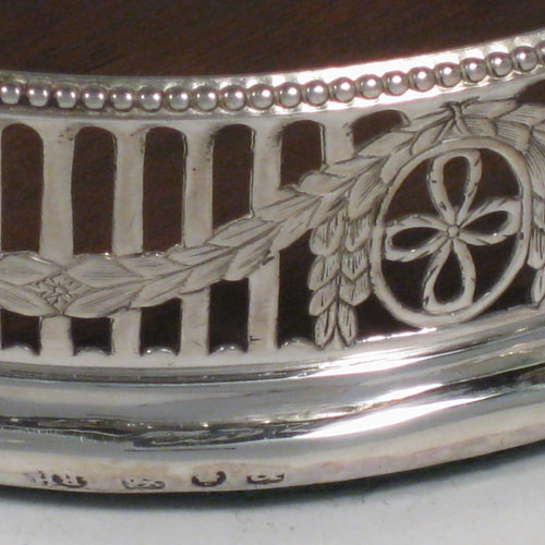    Antique Georgian sterling silver pair of Neoclassical wine coasters, having hand-pierced walls with acanthus-leaf swags, applied bead-edge borders, and oak bases with ivory buttons. Made by Robert Hennell of London in 1776. Diameter 12.5 cms (5 inches), height 3.5 cms (1.3 inches).