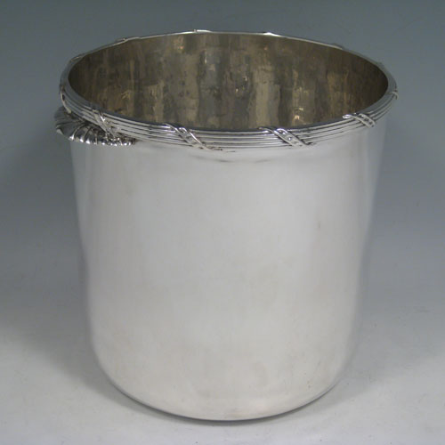    Antique Edwardian sterling silver wine cooler, having a plain cylindrical body, a ribbon and reed top border, two cast fluted handles, and a removable pierced drainer. Made by C.J. Vanders of London in 1906 (originally retailed by Tessiers). Height 16.5 cms (6.5 inches), diameter at top 16.5 cms (6.5 inches). Total weight approx. 1,200g (38.7 troy ounces).