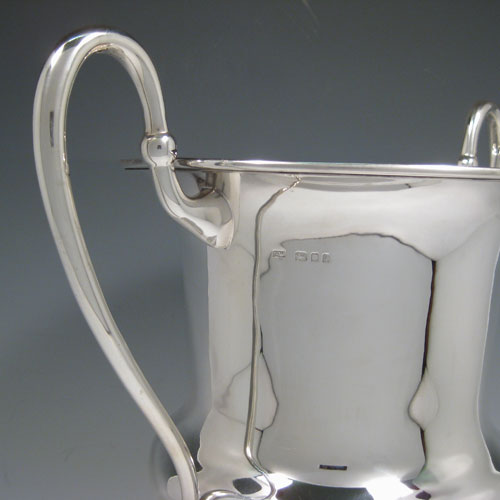 Sterling silver large wine bottle cooler / trophy cup, having a plain round baluster body, with two scroll handles, and sitting on a pedestal foot. Made by Catchpole and Williams of London in 1925. Height 36 cms (14.25 inches), spread across arms 35 cms (13.75 inches). Weight approx. 1,560g (50.3 troy ounces)