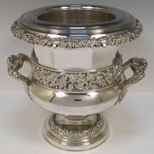 A very handsome Antique Georgian Old Sheffield plated wine cooler, in the Campagna style, with cast gadroon, scroll, and floral borders, a pair of cast side-handles, with a central applied band of grape-vine work, with its original tin-backed interior liner and cover, and all sitting on a pedestal foot. This beautiful antique Old Sheffield plated wine cooler was made in ca. 1825. The dimensions of this fine hand-made antique Old Sheffield wine cooler are height 23 cms (9 inches), and width across handles 26 cms (10.25 inches).  