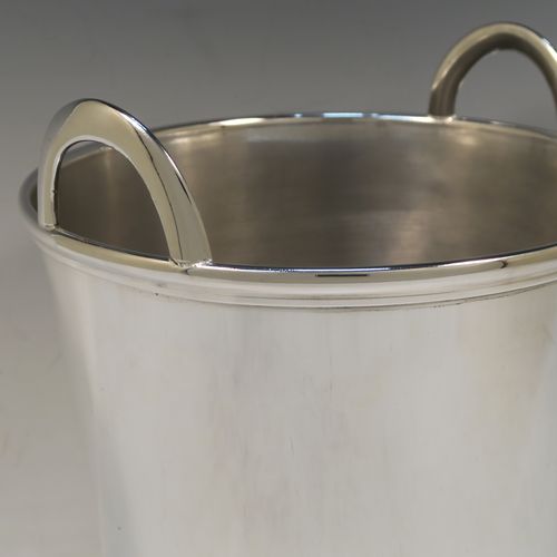 A large and very elegant Art Deco style Silver Plated wine bottle cooler, having a plain round body with tapering sides, and two cast loop side-handles, all sitting on a flat base. This beautiful silver-plated wine cooler was made in ca. 1930. The dimensions of this fine hand-made silver-plated Art Deco wine cooler are height 27 cms (10.5 inches), and diameter at lip 22 cms (8.75 inches). Please note that this will easily hold two normal size wine  bottles.  