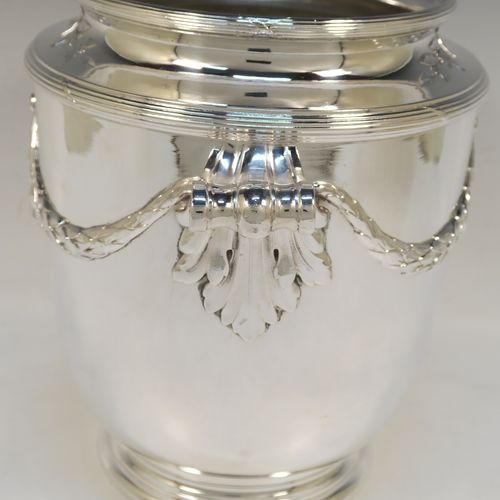 A very elegant Neoclassical style Antique Victorian silver-plated wine cooler, having a plain round body with tapering sides, with beautiful applied acanthus leaf swags, two cast scroll side-handles, and all sitting on a pedestal foot. This handsome antique silver plated wine bottle cooler was made in ca. 1880. The dimensions of this fine hand-made antique silver wine cooler are height 24 cms (9.5 inches), width across handles 25.5 cms (10 inches).   