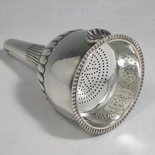 Antique Georgian sterling silver wine decanting funnel, having a round body with hand-chased half-fluted decoration, and a pull out strainer with a shell clip and gadroon border. Made by Alexander Field of London in 1816. The dimensions of this fine hand-made silver wine decanting funnel are height 15 cms (6 inches), diameter of cup 8.5 cms (3.25 inches), and it weighs approx. 117g (3.7 troy ounces).   