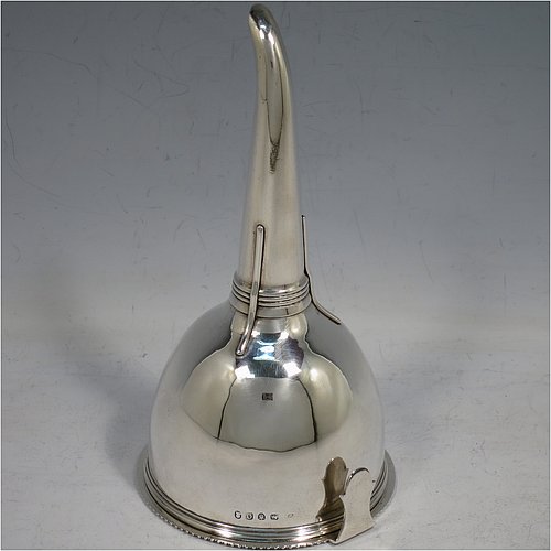 An Antique Georgian Sterling Silver wine decanting funnel, having a round body with an applied gadroon border and funnel struts (that allow proper aeration when decanting), a pull out strainer with a shaped clip, and an original muslin ring. Made by William Bateman of London in 1811. The dimensions of this fine hand-made antique silver wine decanting funnel are height 16 cms (6.3 inches), diameter of cup 8.5 cms (3.3 inches), and it weighs approx. 147g (4.7 troy ounces).    