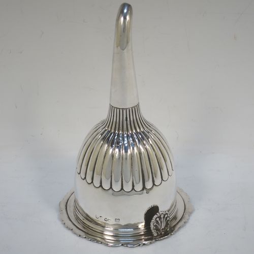 A very handsome Antique Georgian Sterling Silver wine decanting funnel, having a round body with hand-chased half-fluted decoration, and a pull out strainer with a shell clip and a shell and scroll border. Made by William Eley and William Fearn of  London in 1826. The dimensions of this fine hand-made silver wine decanting funnel are height 15 cms (6 inches), diameter of cup 9.5 cms (3.75 inches), and it weighs approx. 198g (6.4 troy ounces).   