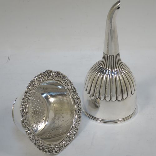 A very handsome Antique Georgian Sterling Silver wine decanting funnel, having a round body with hand-chased half-fluted decoration, and a pull out strainer with a shell clip and a shell and scroll border. Made by William Eley and William Fearn of  London in 1826. The dimensions of this fine hand-made silver wine decanting funnel are height 15 cms (6 inches), diameter of cup 9.5 cms (3.75 inches), and it weighs approx. 198g (6.4 troy ounces).   